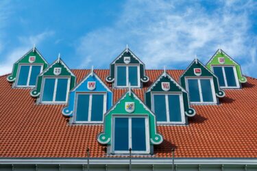 Colorful dormer windows on a red tile roof in Zaandam, Netherlands.